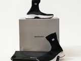 Des baskets noires et blanches sont posées sur une boîte