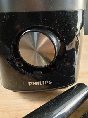 un mixeur noir et argent posé sur une table en bois