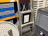 une pile de chaises et un téléviseur dans un entrepôt