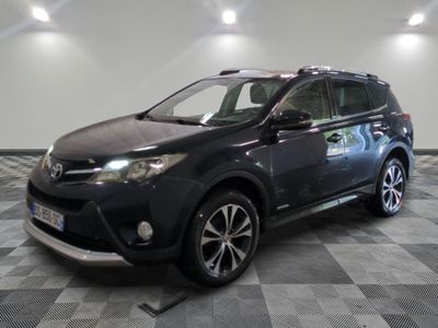 La Toyota RAV noire est garée dans une pièce dont le sol est à carreaux.
