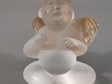 une figurine en verre représentant un bébé assis par terre