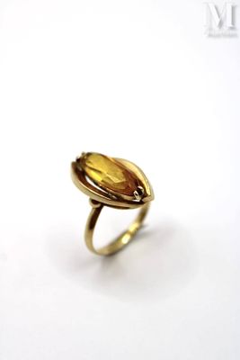 a close up of a ring with a yellow stone in it