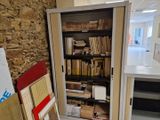 une porte ouverte dans une pièce où les étagères sont remplies de livres