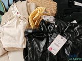 a pile of clothes that is sitting on a bed