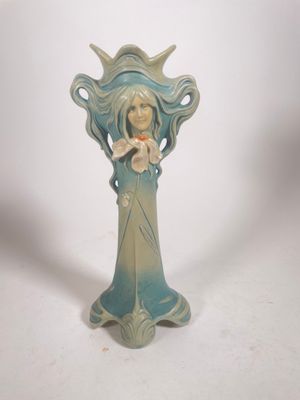 statue d'une femme tenant une fleur dans ses mains
