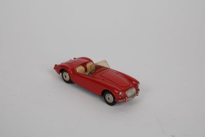 une petite voiture rouge posée sur une surface blanche