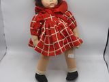 une poupée en robe rouge sur fond blanc