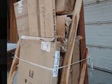 a pile of boxes sitting on top of a pallet in front of a garage door