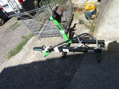 un caddie muni d'une poignée verte, posé sur le bord de la route