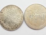 two coins are shown side by side on a white surface