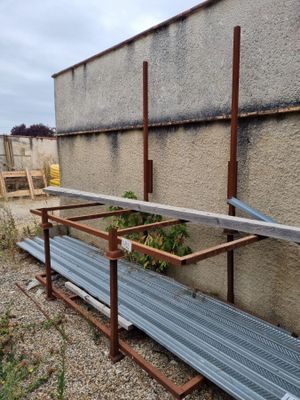 a metal bench that is sitting on the side of a building