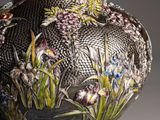 a silver vase with a floral design on it
