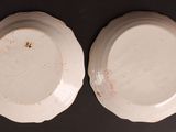 two white plates sitting on top of a table next to each other