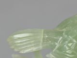 a green bird that is sitting on top of a table