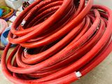 a pile of red hoses sitting on a pallet