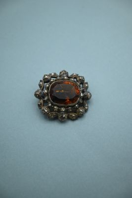 a close up of a broochle on a table with a blue background