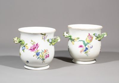 two white vases with floral designs on them sitting side by side