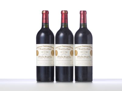 three bottles of red wine sitting on top of a white table