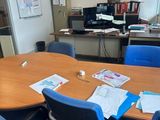 une table sur laquelle sont posés plusieurs papiers, dans une pièce