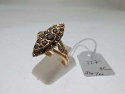 un gros plan d'une bague en or sertie de pierres noires