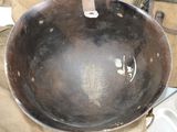 an old frying pan sitting on top of a piece of luggage