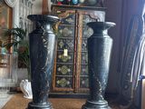 two black vases sitting on the floor in a room
