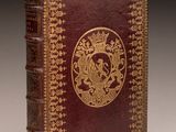 an old book with a gold and red design on it