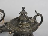 a silver teapot with a bird on it