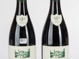 deux bouteilles de vin posées l'une à côté de l'autre sur une surface blanche