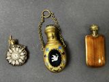 trois types différents de flacons de parfum et un collier posés sur une table