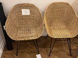 two wicker chairs sitting next to each other on the floor