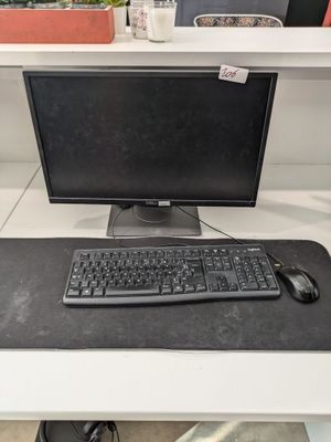 un clavier et une souris posés sur un bureau, à côté d'un écran