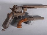 un petit pistolet en bois muni d'une crosse en bois, posé sur une surface blanche