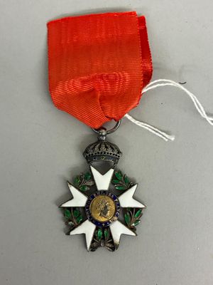 une photo représentant une médaille entourée d'un ruban, posée sur une table