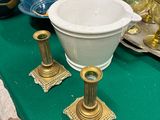 une table verte sur laquelle sont posés un bol blanc et des bougeoirs dorés