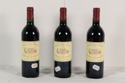 trois bouteilles de vin rouge sont alignées sur une table