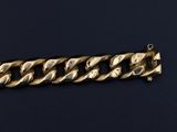 a close up of a gold chain bracelet on a black background