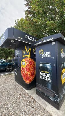 two boxes with pizzas painted on them on the side of the street
