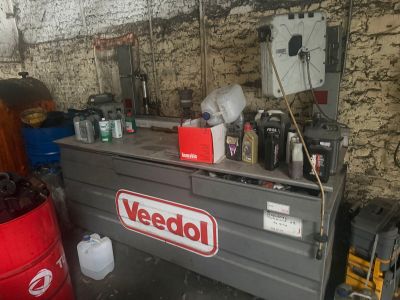 a dumpster that is sitting in a garage next to a trash can