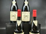 trois bouteilles de vin rouge posées sur une caisse en bois