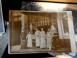an old photo of a group of people standing in front of a store