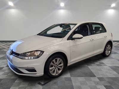 a white volkswagen golf is parked in a room with checkered floor