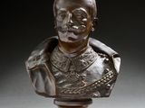 un buste en bronze représentant un homme moustachu, posé sur un socle