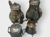 three silver teapots and a tea pot on a white background