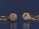 deux paires de boucles d'oreilles en or et diamants sur un fond bleu