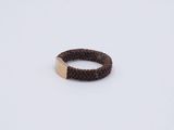 the ring is made of brown rope and has a gold plate on it