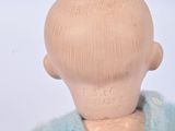 a wooden doll with a blue and yellow sweater on