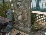 a statue of a man on a bench next to a fire hydrant