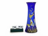 un vase bleu orné d'un motif de poisson rouge, à côté d'une bague en diamant
