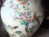 a vase that has a bird and flowers on it